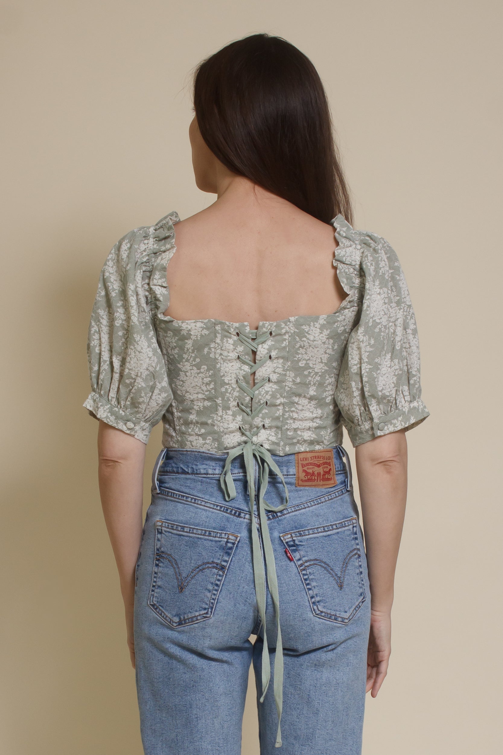 Olivaceous floral jacquard corset top with puff sleeves, in sage cream. (Back)