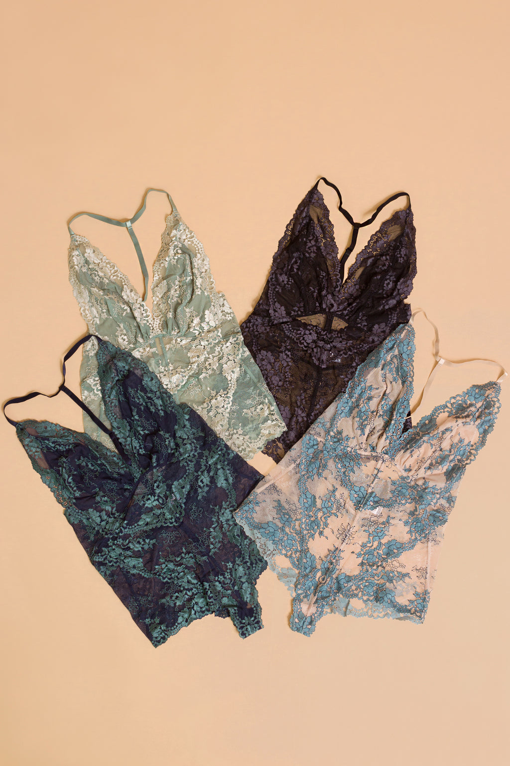 Lace bodysuit flatlay, in assorted colors.